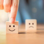 Fidéliser mes clients : Un client satisfait montre un dé souriant
