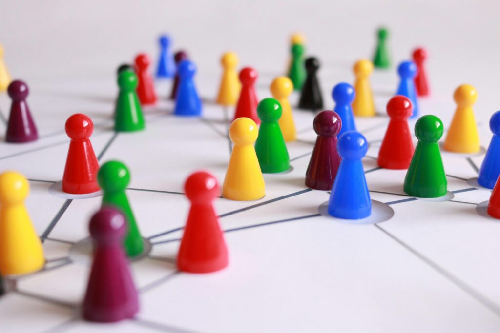 Des pions colorés sur une feuille de papier symbolisent les échanges et mouvements entre les membres d'un marketing de réseau. 