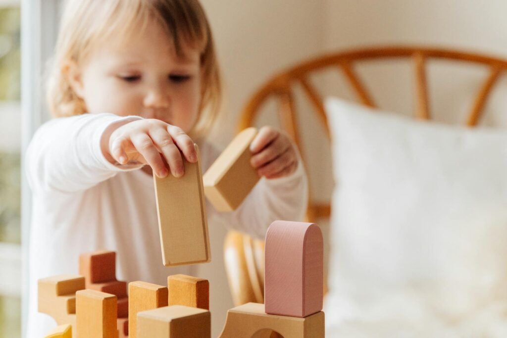 Un jeune enfant est concentré sur une construction typique d'un jeu d'éveil. 